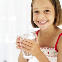 portrait of a young girl holding a glass of water